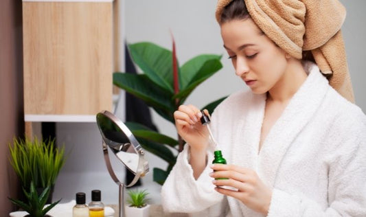 Young woman applying face Anti-Aging Peptide Serum.