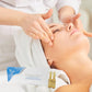 Beautician doing facial massage to a woman's face and box of Alpha Lipoico ampoules